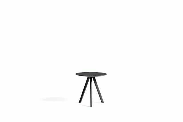 Small black round table with three angled legs on a white background
