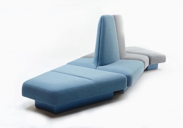 Blue modular lounge chair with a tall backrest and low seat on a white background