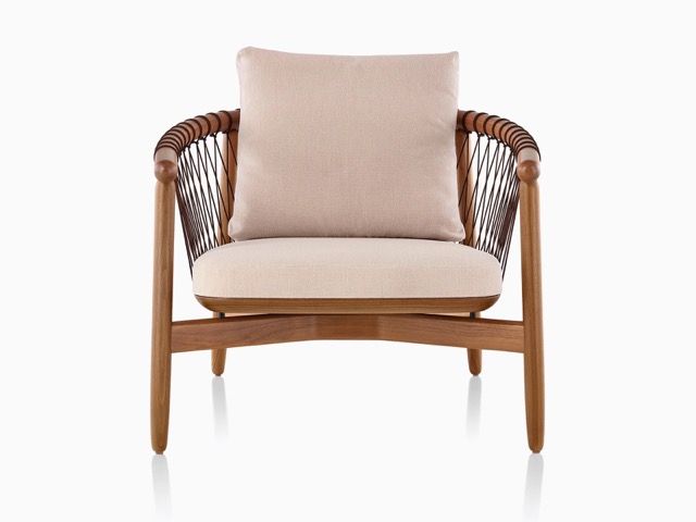 Beige cushioned armchair with wooden frame and woven sides on a white background