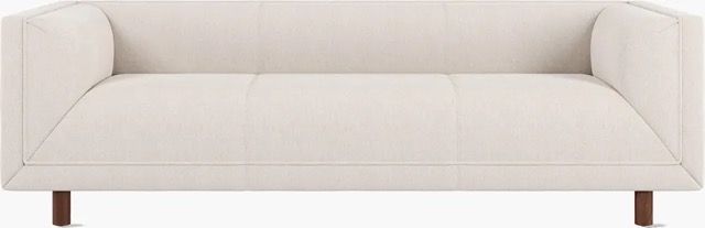 Modern white sofa with wooden legs on a plain background