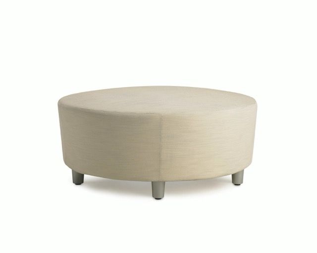 Beige round upholstered ottoman on four short dark legs