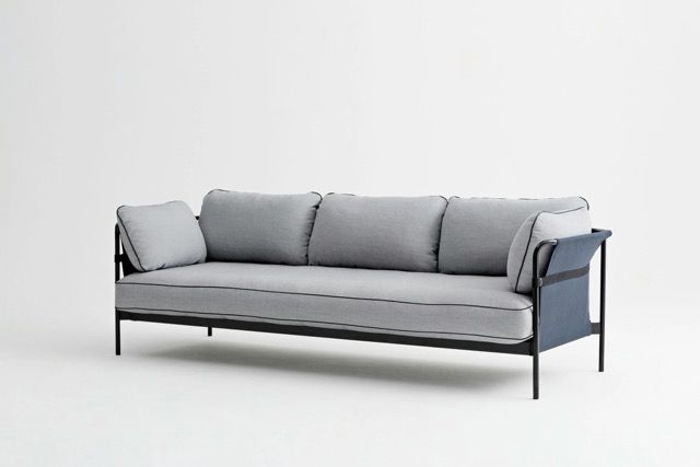 Gray outdoor sofa with black metal frame and two cushions on a white background