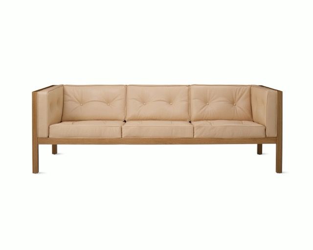 Beige tufted three-seat sofa with wooden frame on a white background