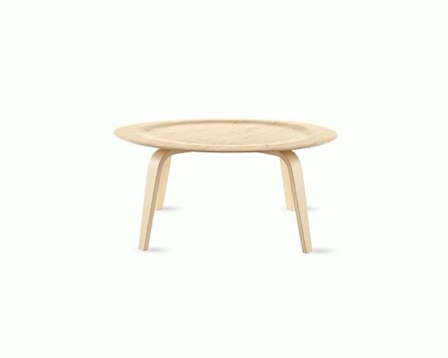 Light wood oval coffee table with four tapered legs on a white background