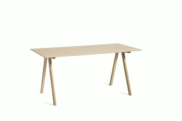 Minimal light wood desk with angled legs on a white background