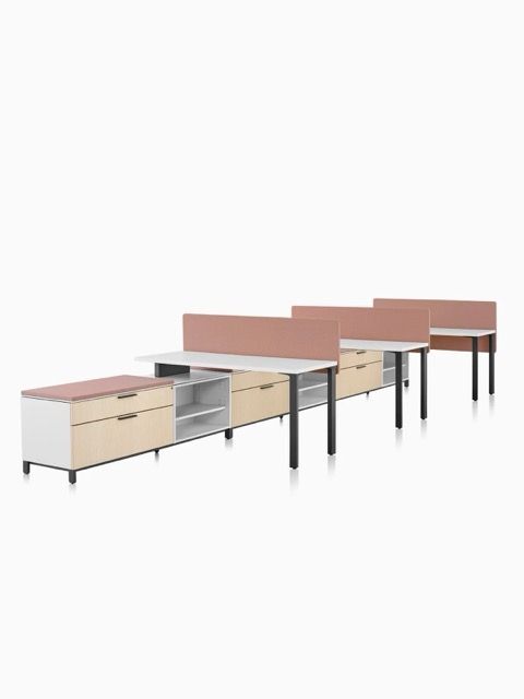 Row of modern office desks with pink privacy panels and black legs on a white background