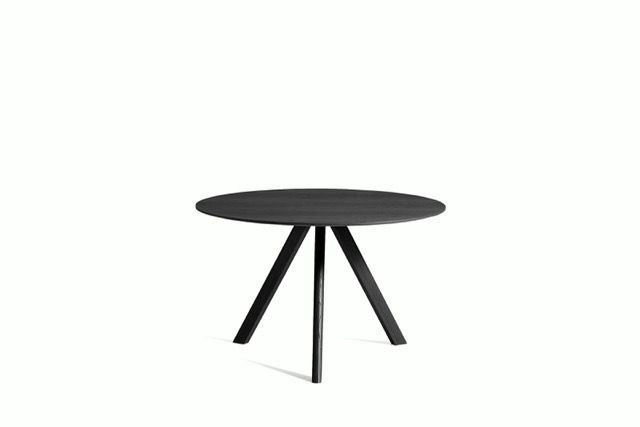 Black round table with three angled legs on a white background