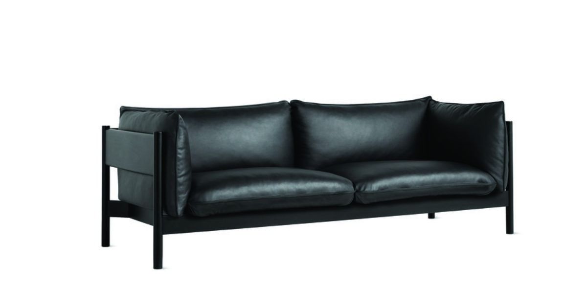 Black leather loveseat with metal frame on a white background