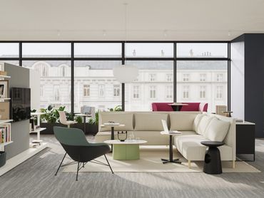 Modern living room with beige sofa, green chair, coffee tables, and large city-view windows