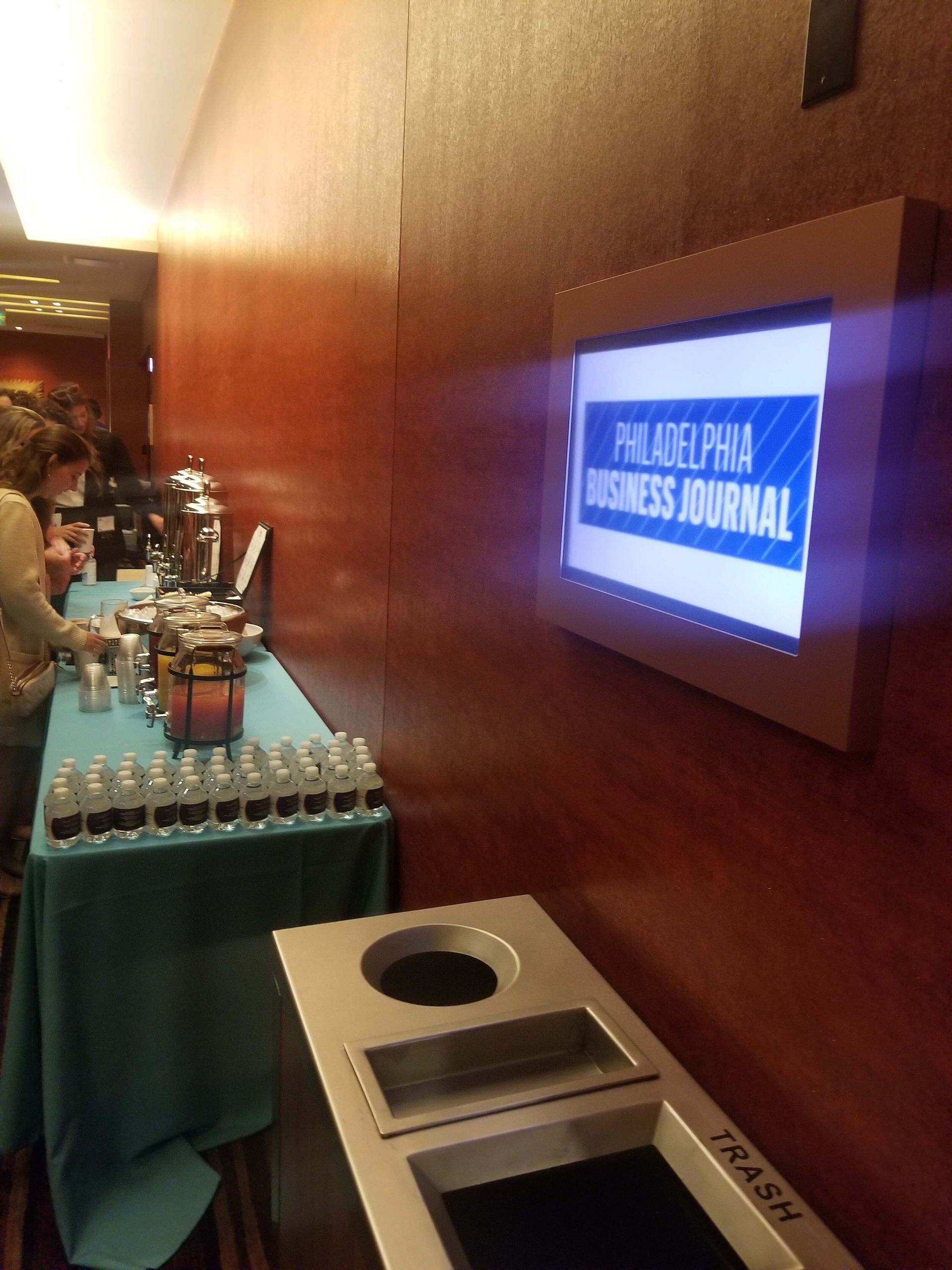 Buffet table beside wall-mounted sign reading “Philippine Business Journal” in a conference hallway