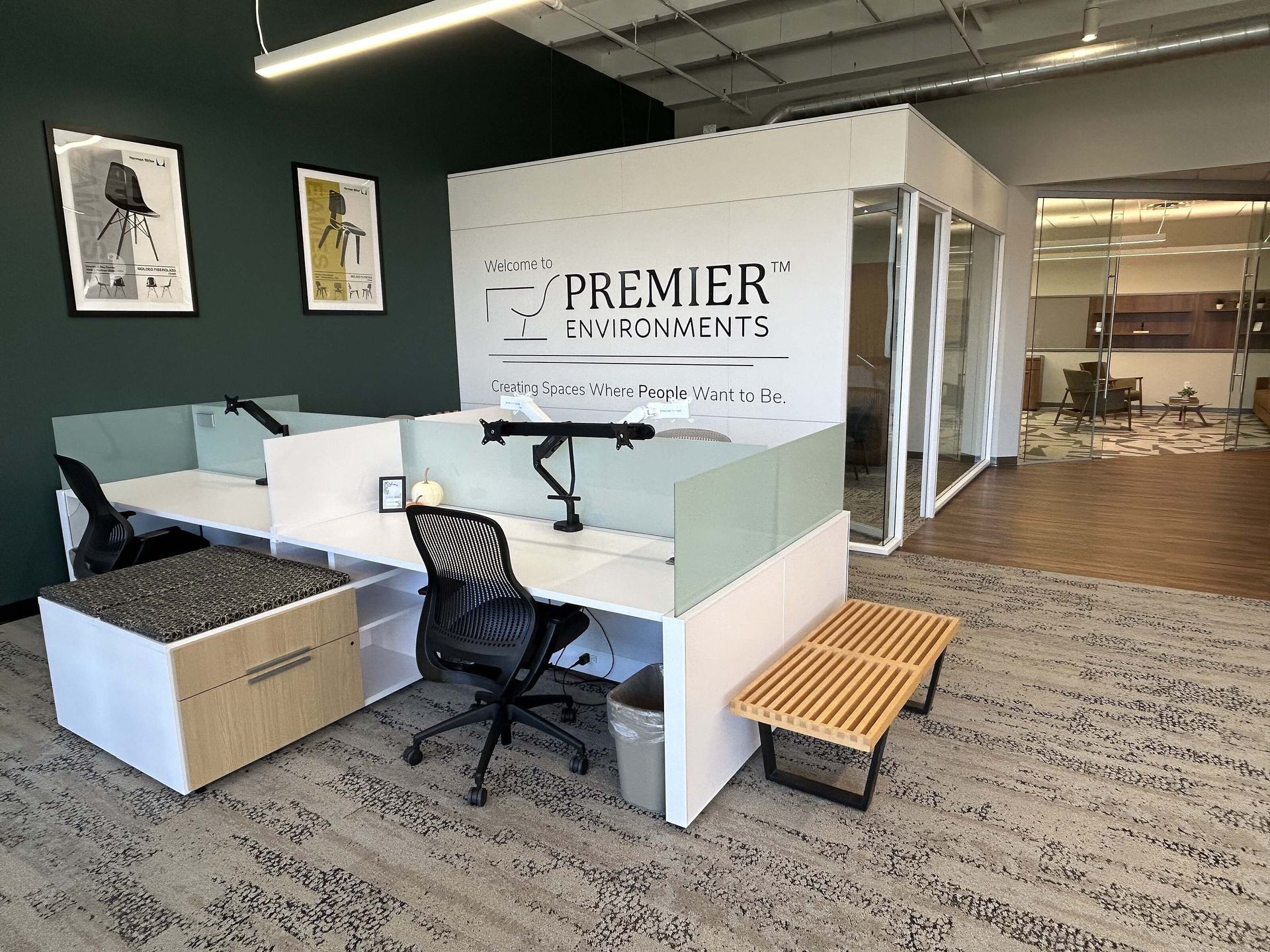 Open office with white desks, black chairs, and a “Premier Payments” wall sign.