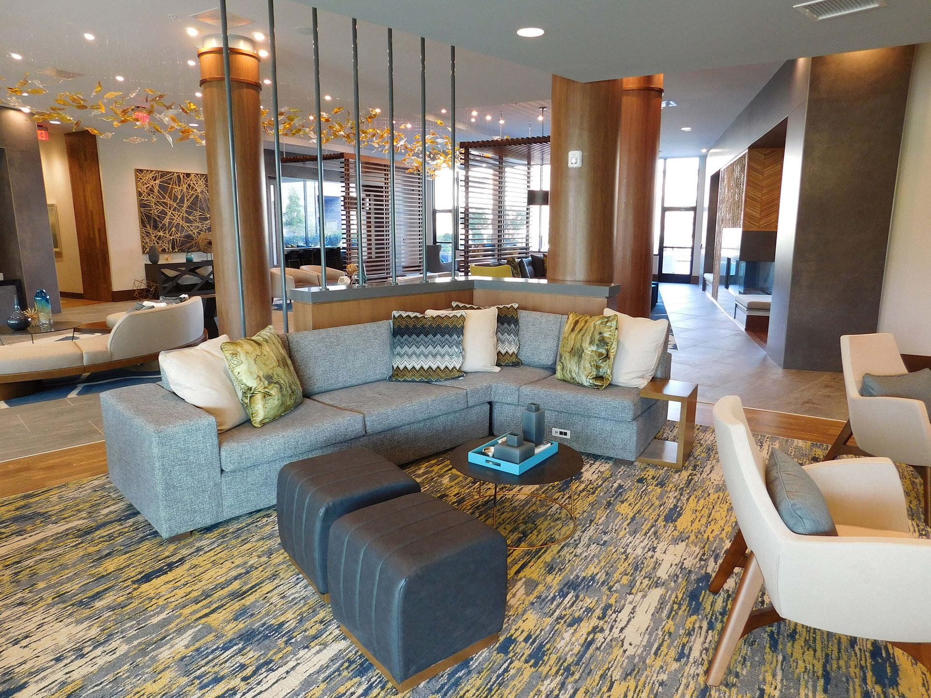 Modern hotel lobby with curved sofa, ottomans, and warm wood accents
