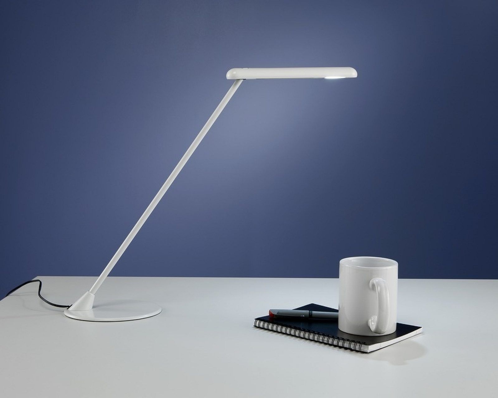 Black adjustable desk lamp with a long angled arm and round base on a white background