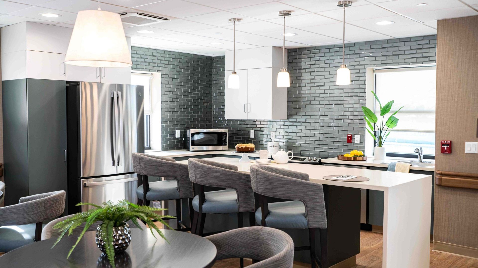 Modern open kitchen with stainless steel appliances, island seating, and pendant lights