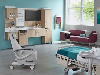 Modern hospital room with a bed, medical workstation, and window seating in teal and wood tones