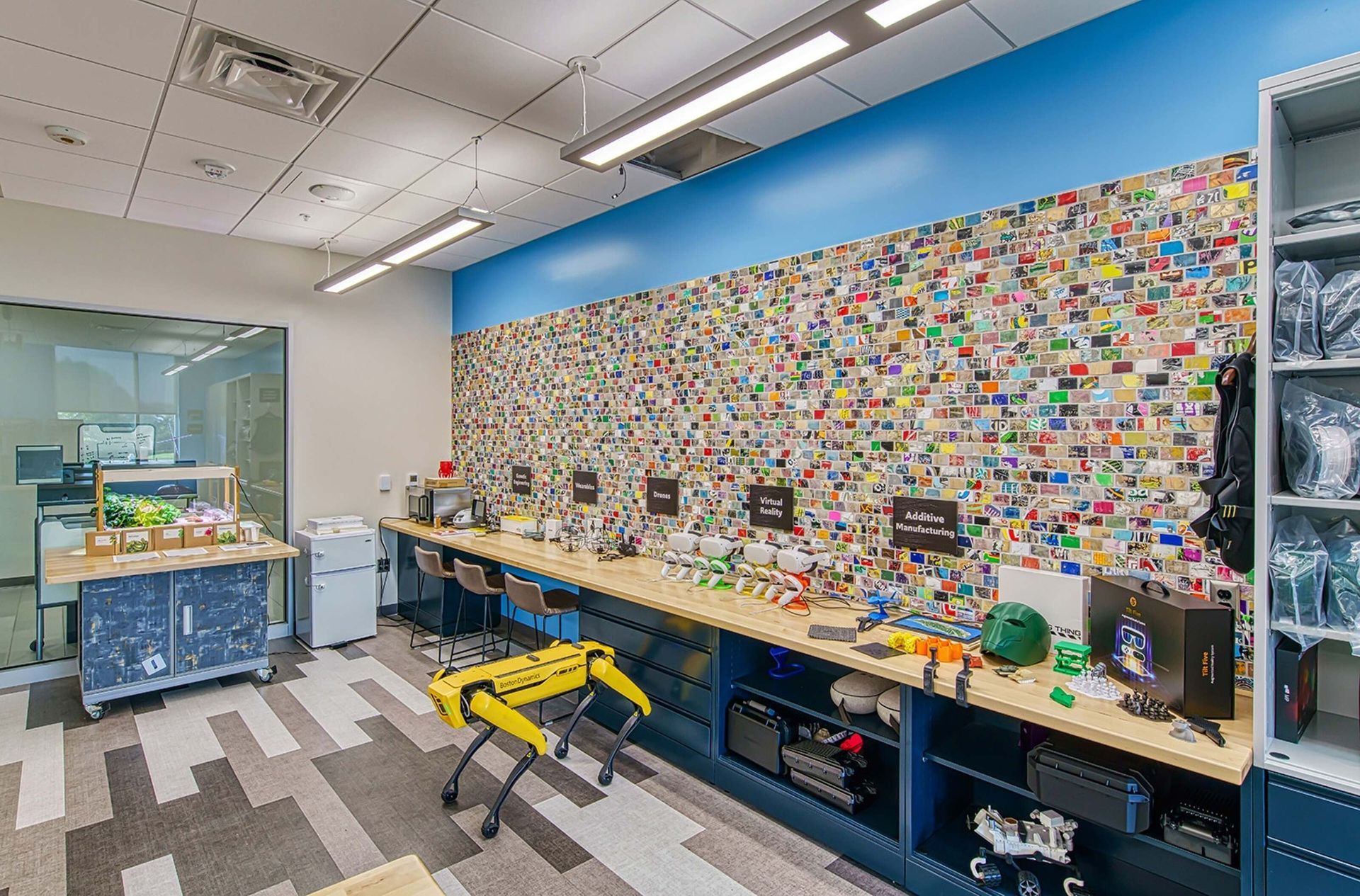 Bright workshop with long workbench, tools, colorful wall display, and a yellow step stool.