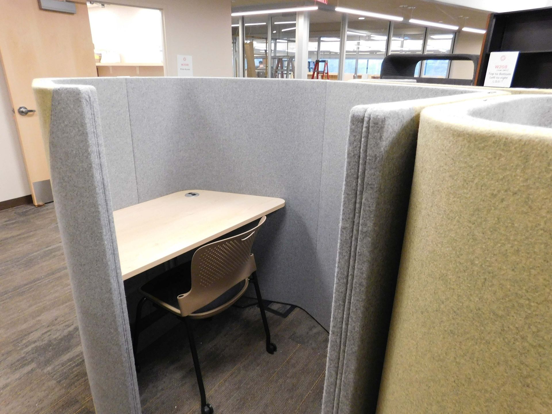 Small gray cubicle workspace with a desk and chair in an office