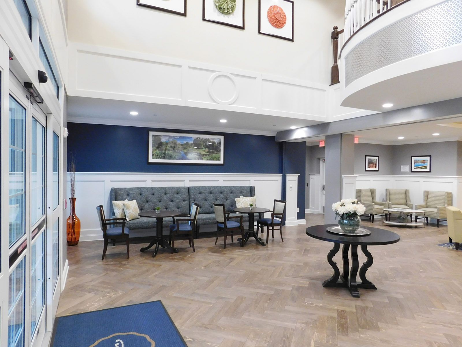 Bright lobby with seating area, blue accent wall, and round table in a modern open atrium
