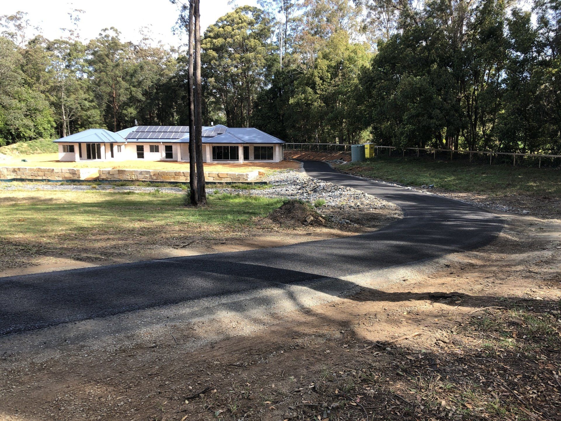 A house is being built on a dirt road in the middle of a forest.
