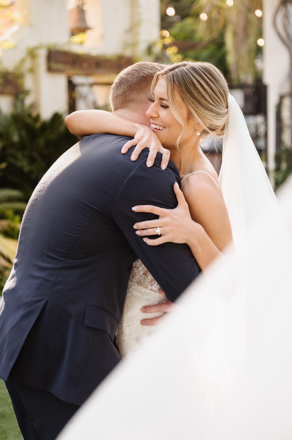 A bride and groom are hugging each other on their wedding day.