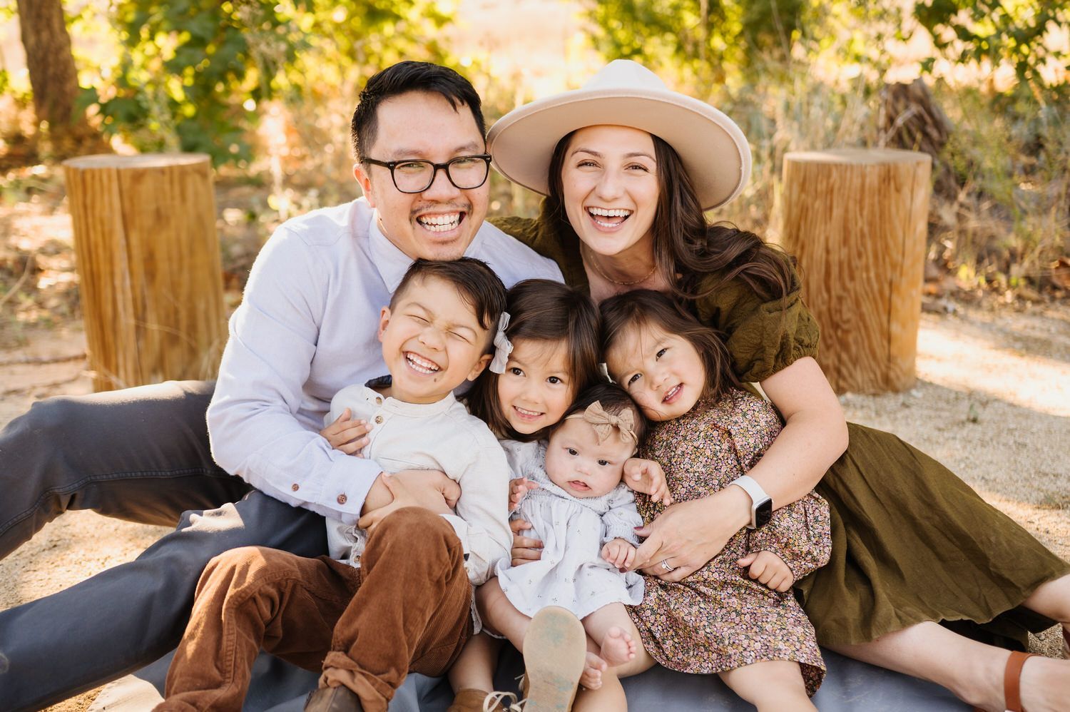 A family is posing for a picture while sitting on a blanket.
