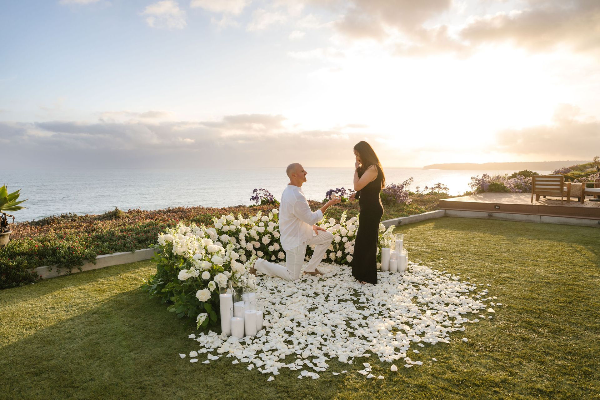 Couple exchanging vows at sunset in Dana Point beside a flower-covered arch overlooking the ocean