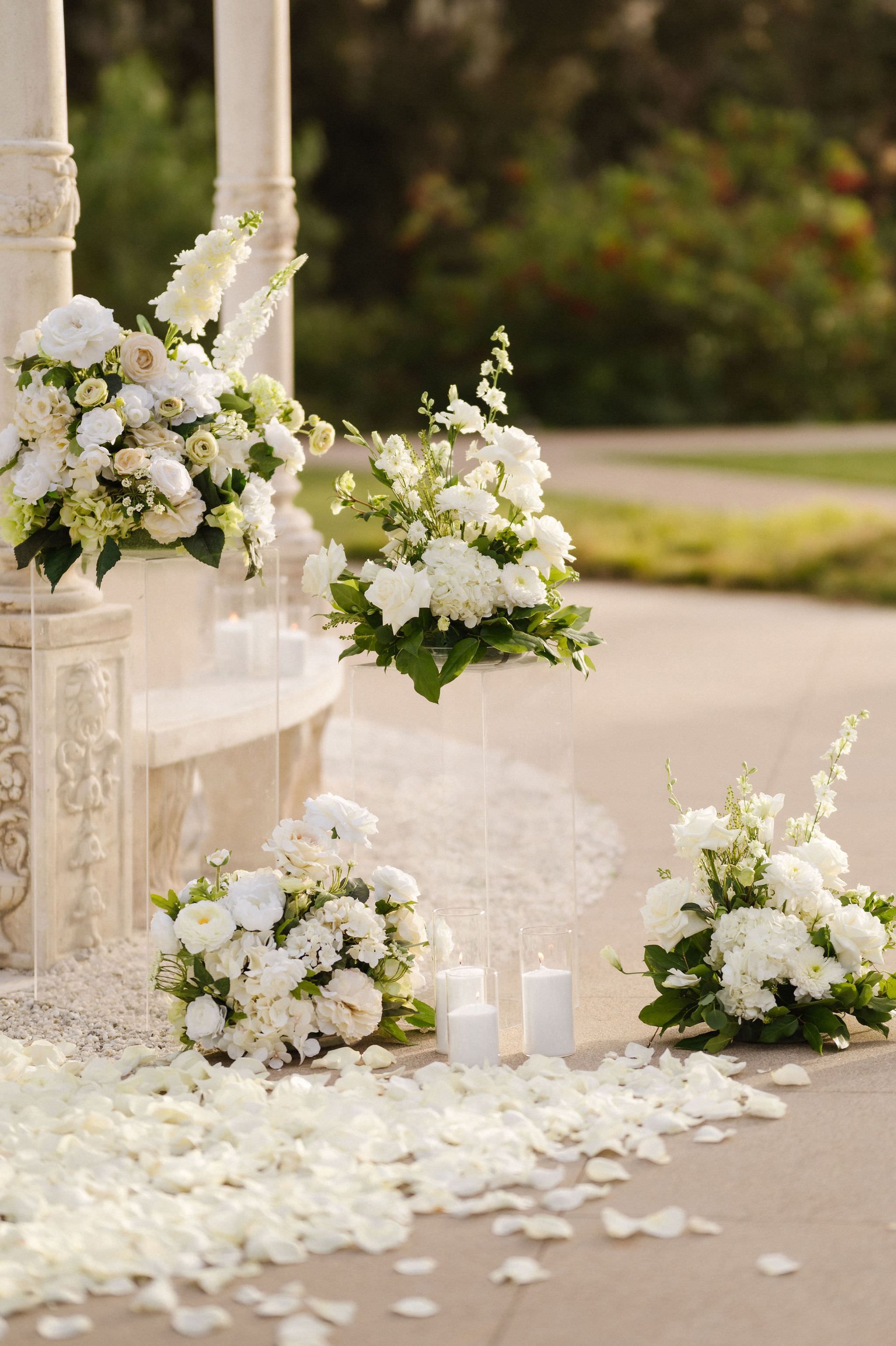 White floral wedding decor with candles and petals on a stone walkway and steps for a proposal with The Yes Girls