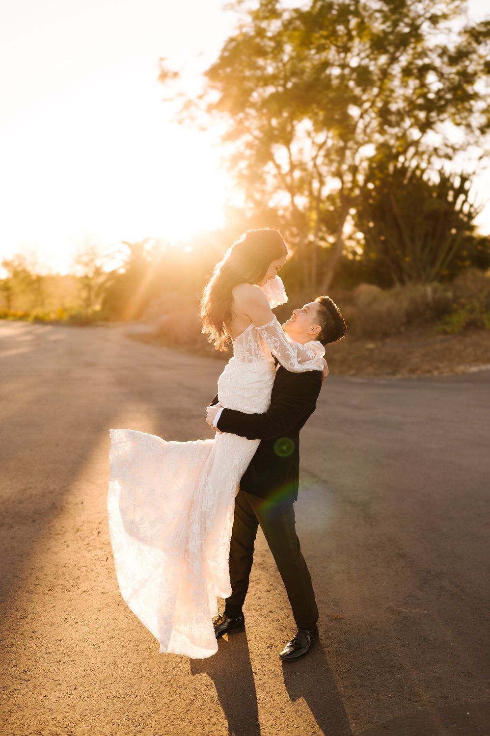 Couple dancing outdoors at sunset at Tivoli, bride’s white dress flowing in warm light.