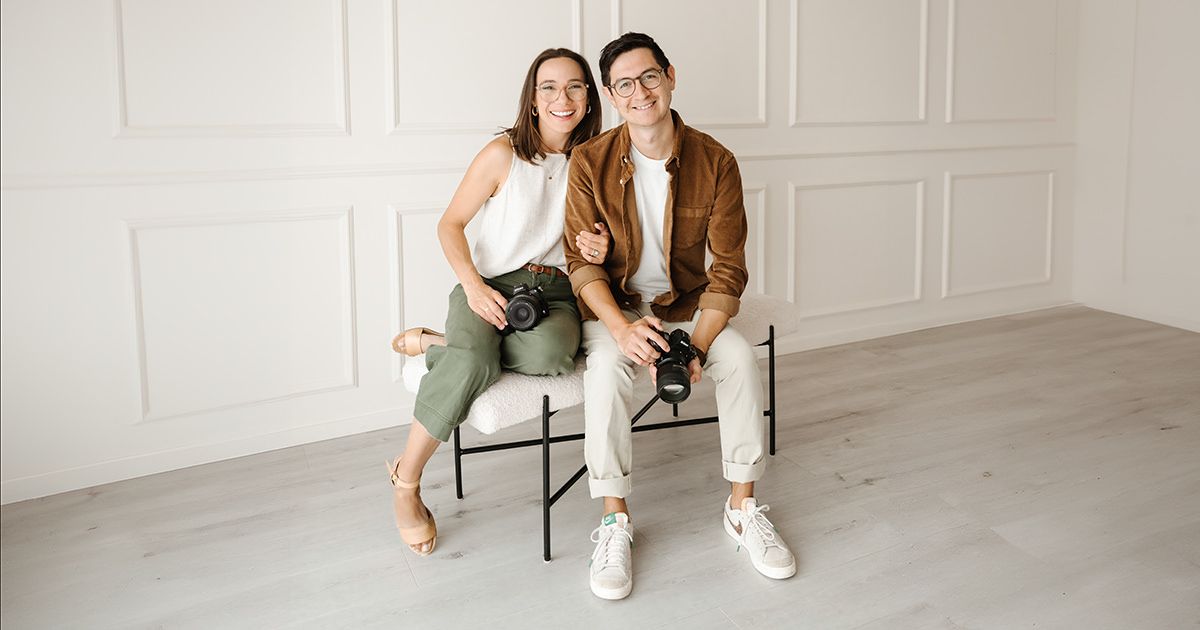 Dan & Tyler sitting on chairs in a bright white room, smiling at the camera.