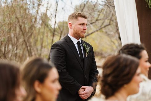 An image of a man about to cry watching his bride walk down the aisle. 
