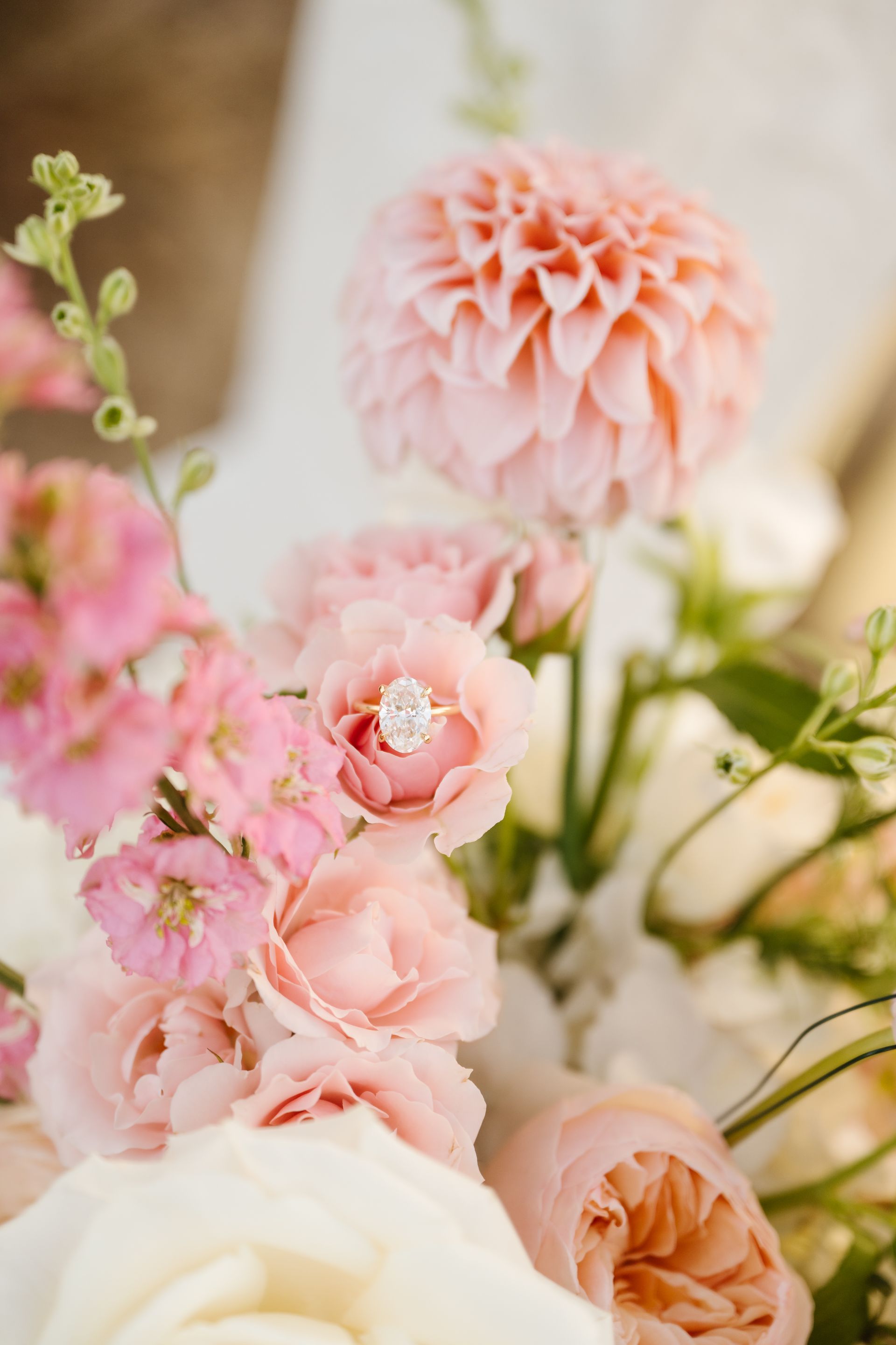 Soft pink and white flowers arranged in a bouquet with a peach dahlia and delicate blossoms.