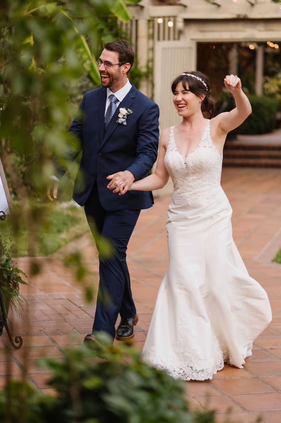 A bride and groom are walking down the aisle holding hands.