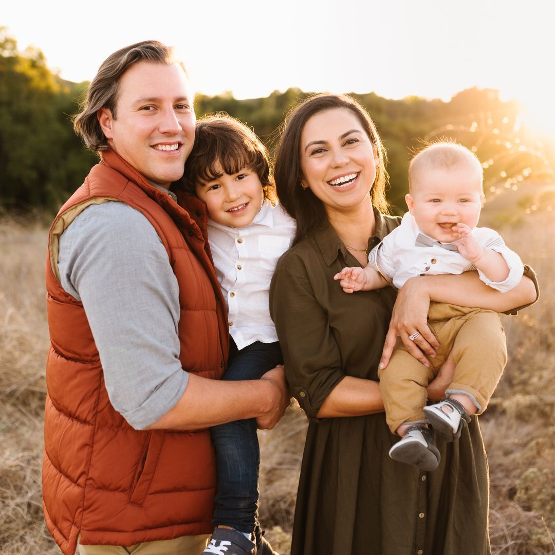 A family is posing for a picture in a field.