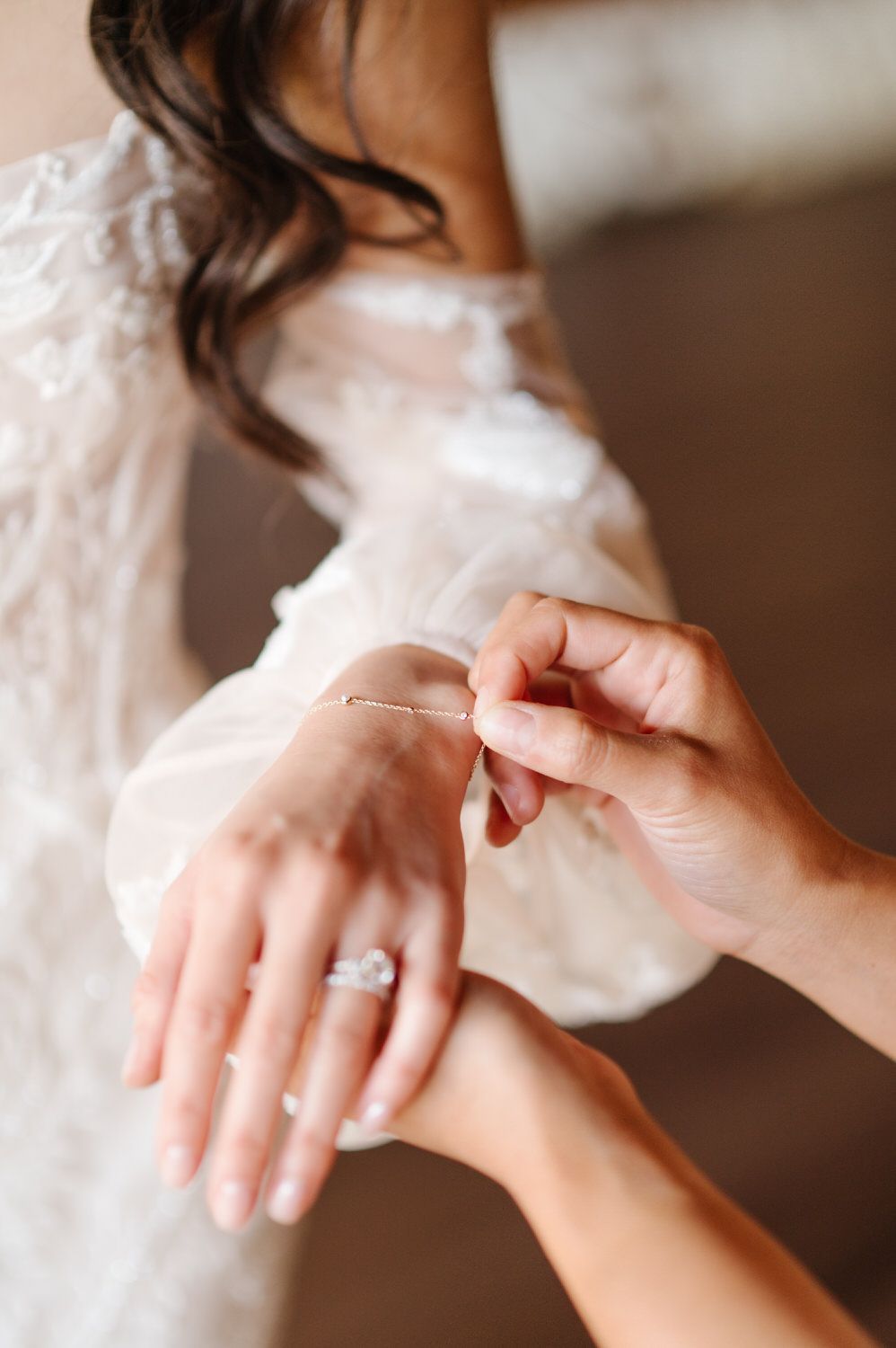 A woman is putting a bracelet on a woman 's wrist.