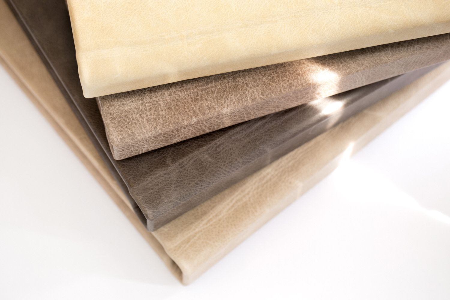 Stacked wedding albums in neutral beige and gray tones