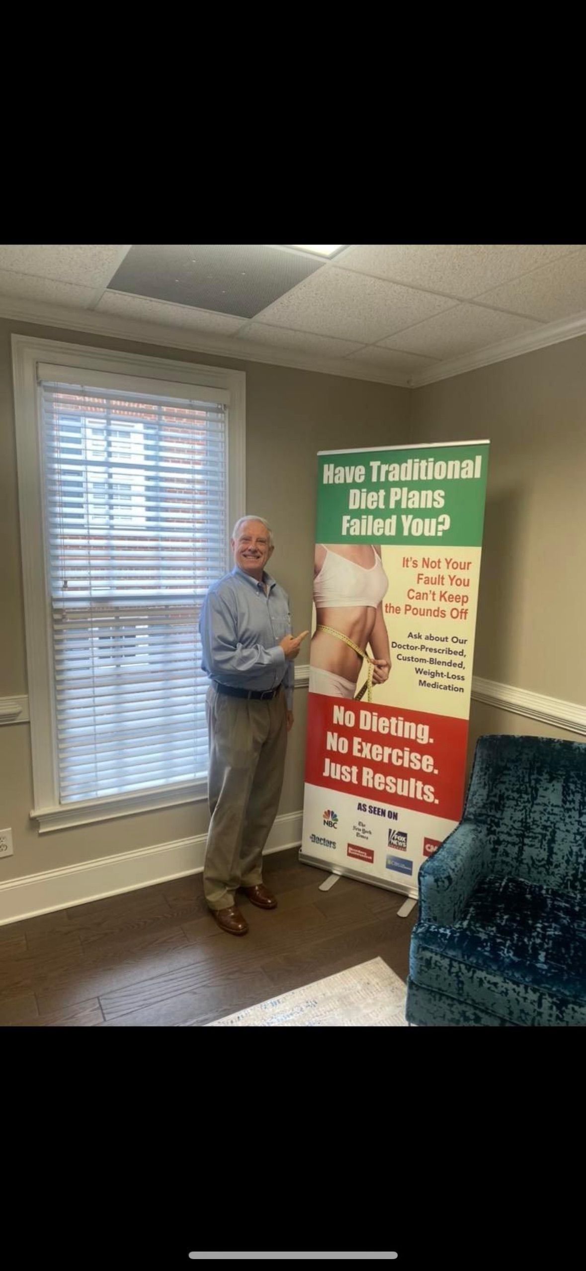 A man is standing in front of a sign in a room.