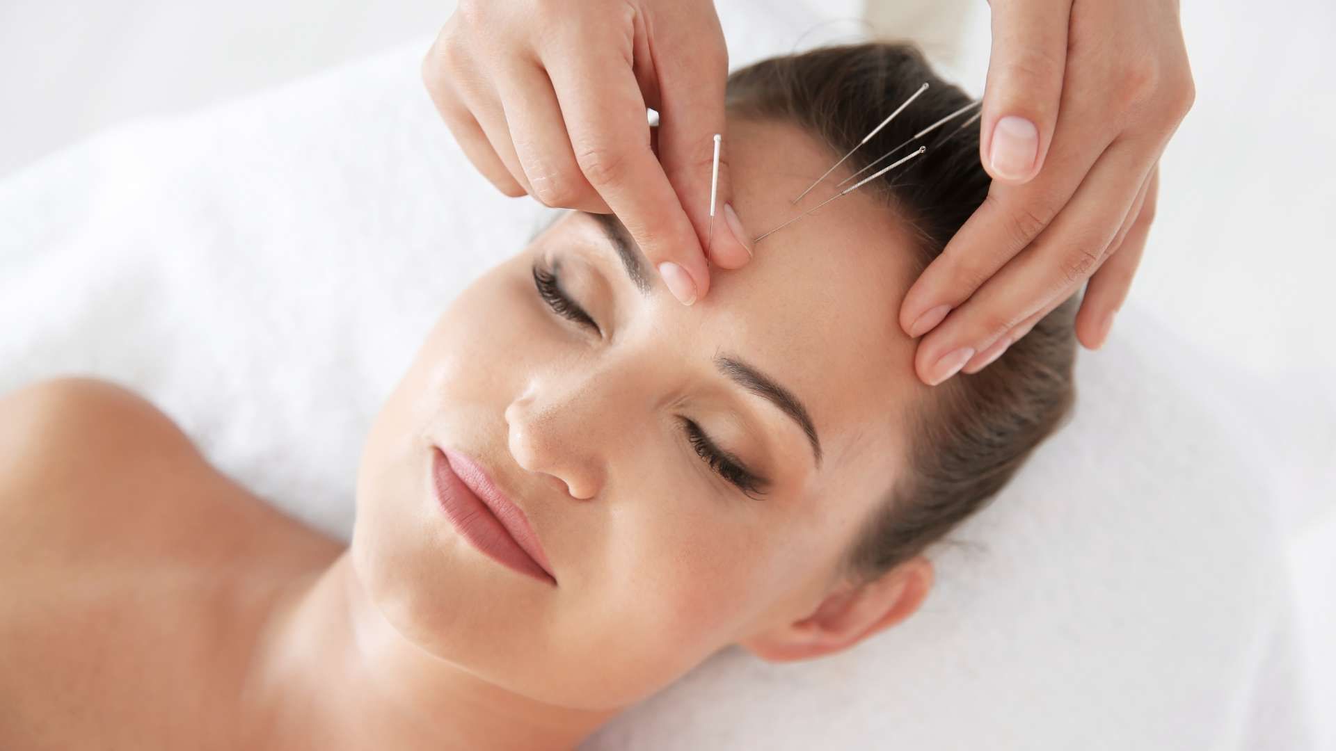 Woman receiving a facial massage with closed eyes in a spa setting