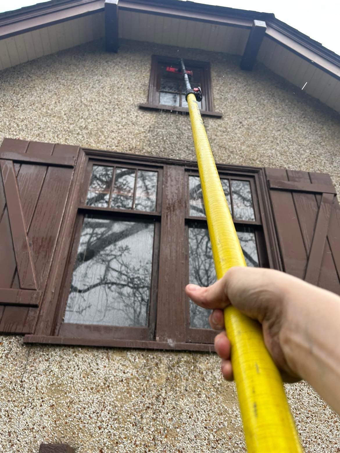 cleaning a window with a tucker, water-fed pole
