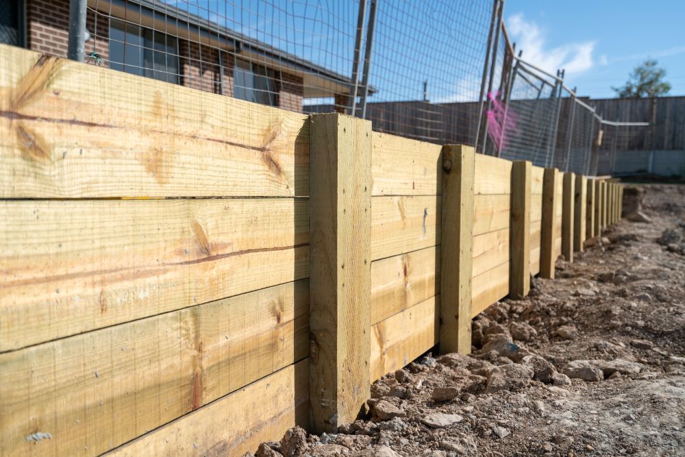 Wooden Retaining Wall Under Construction, Holding Back Dirt — B&T Earthworks & Civil in Redlynch, QLD
