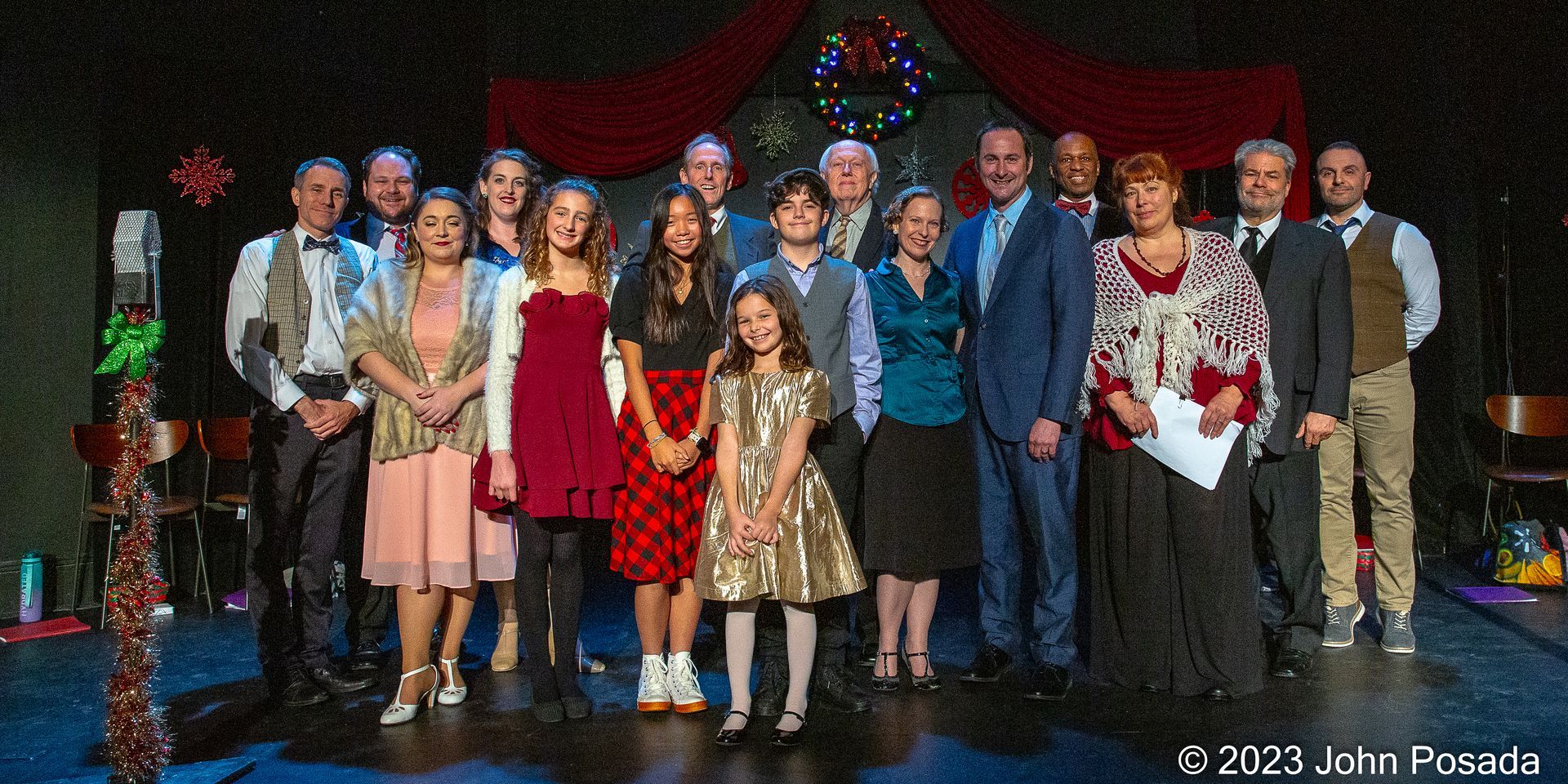 All of the actors lined up on stage posing for a photo.