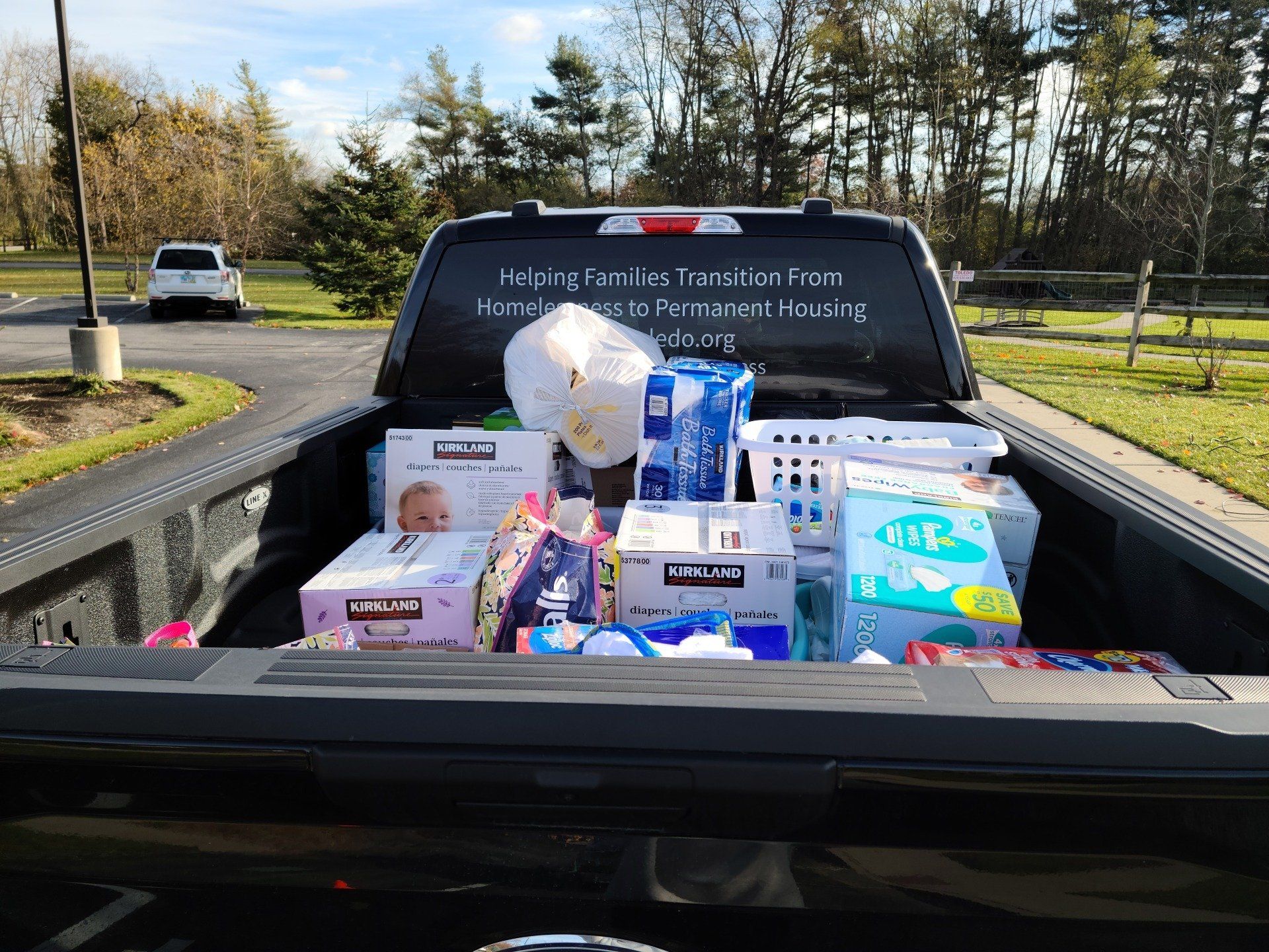 Truck bed filled with donations for families, including diapers and baby supplies. 