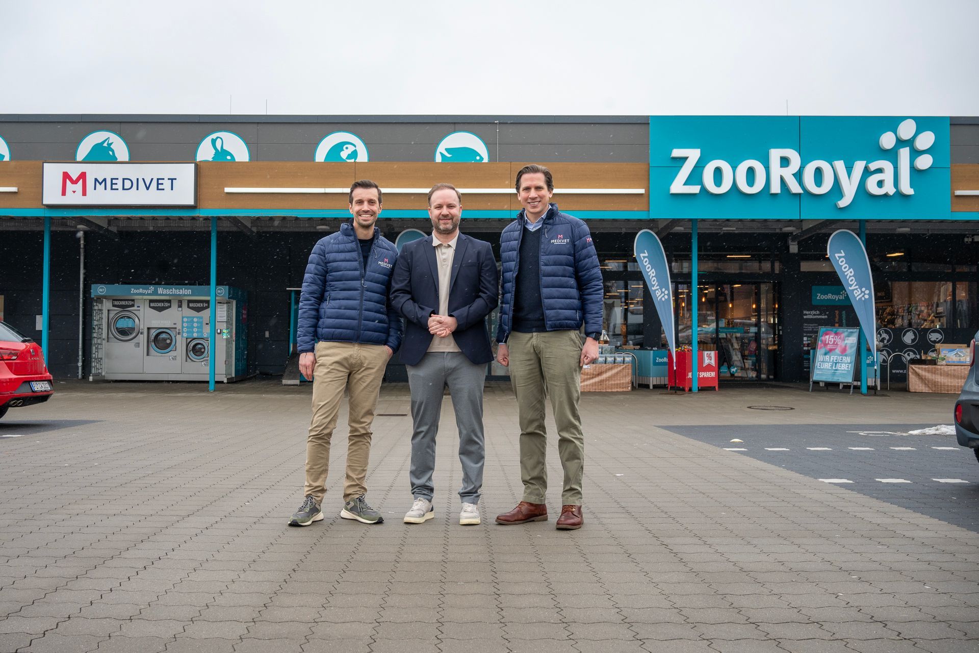 Drei Männer in Jacken stehen vor dem Tiergeschäft ZooRoyal. An dem Gebäude hängt ein rotes MEDIVET-Schild.
