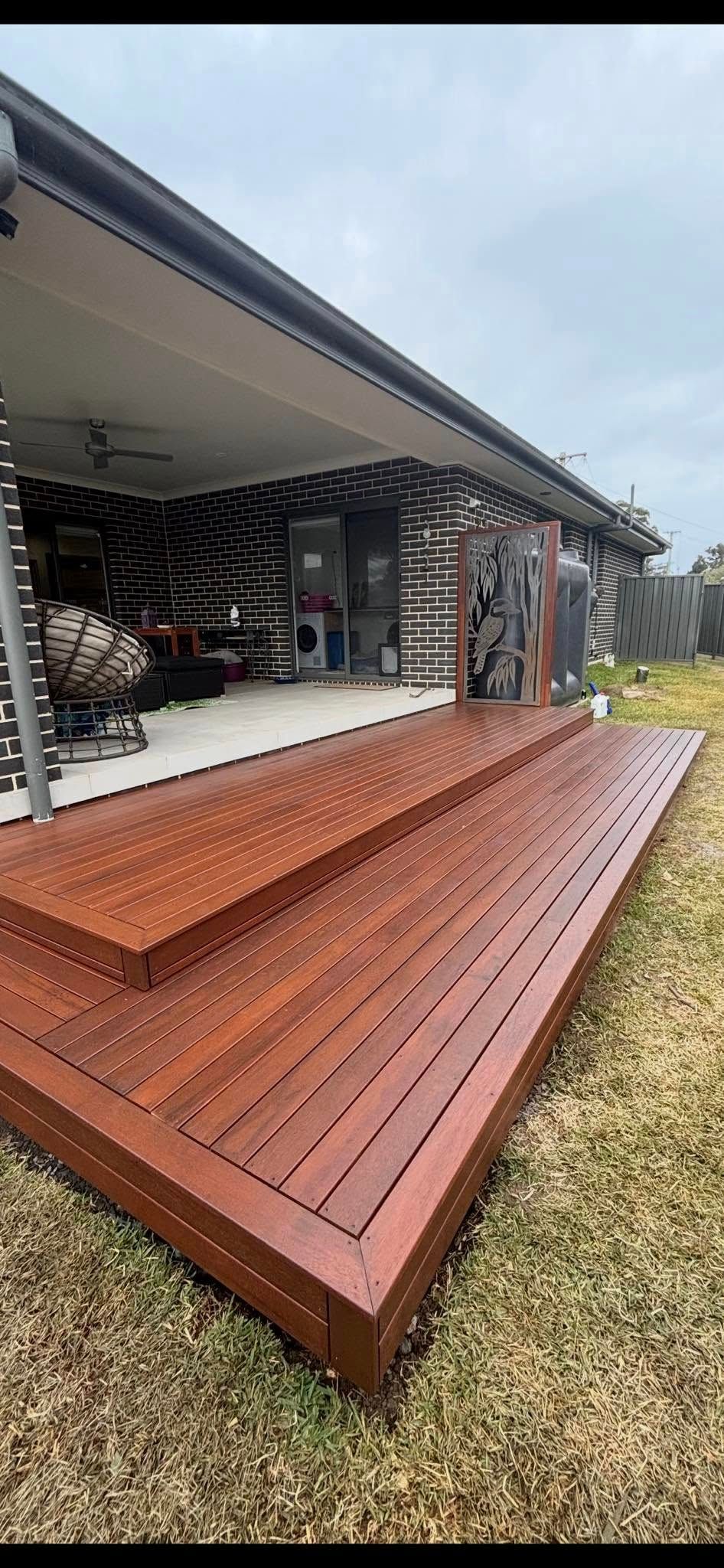Long wooden deck ramp leading to a modern house exterior