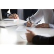 People signing documents at a bright conference table
