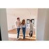 Three people walking through a bright, empty apartment with hardwood floors