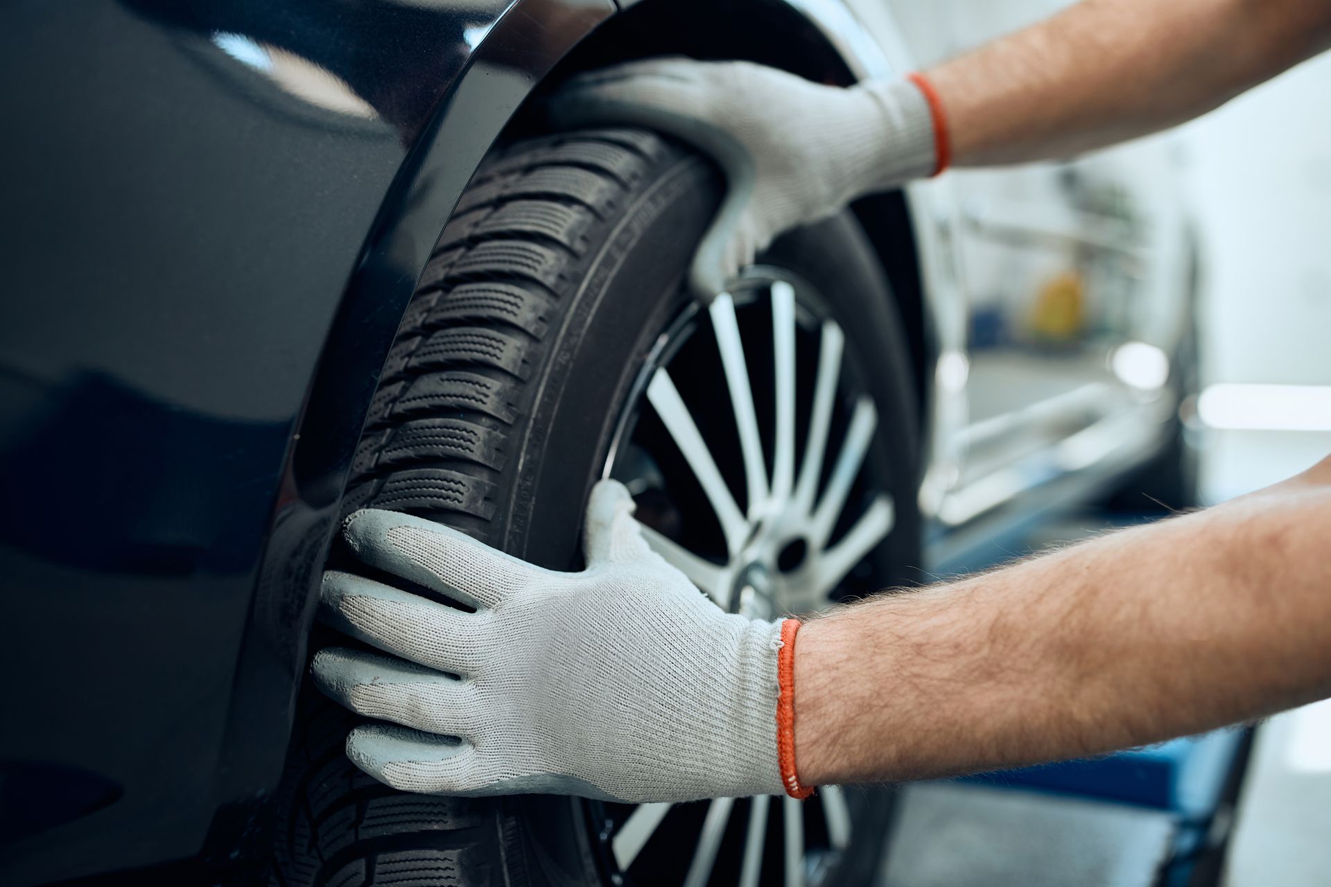 Close-up of a technician changing a tire at a shop providing reliable car repair services. Close-up of a technician changing a tire at a shop providing reliable car repair services.