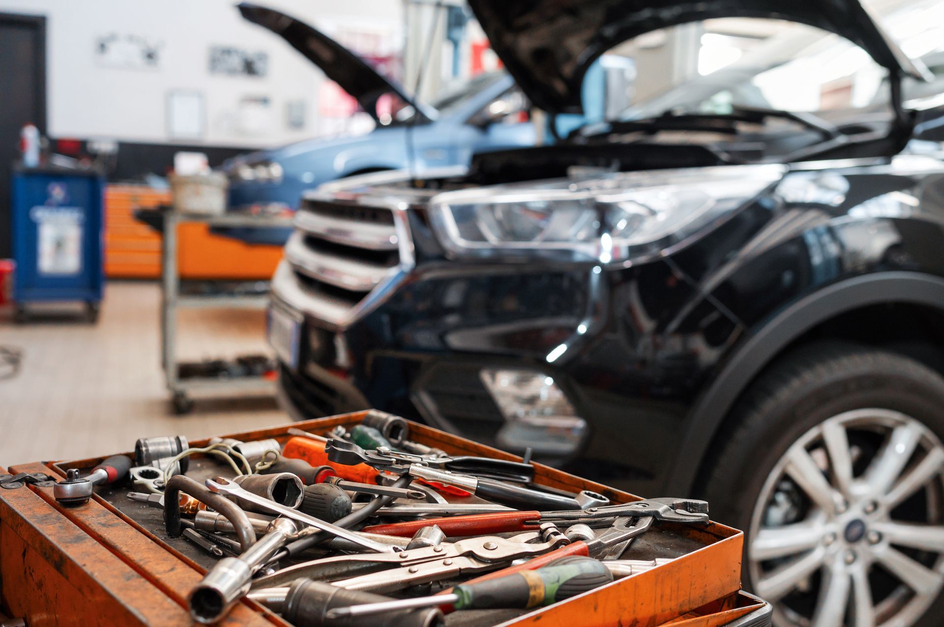 A mechanic holds and rolls a tire at a tire shop showcasing car repair services.]