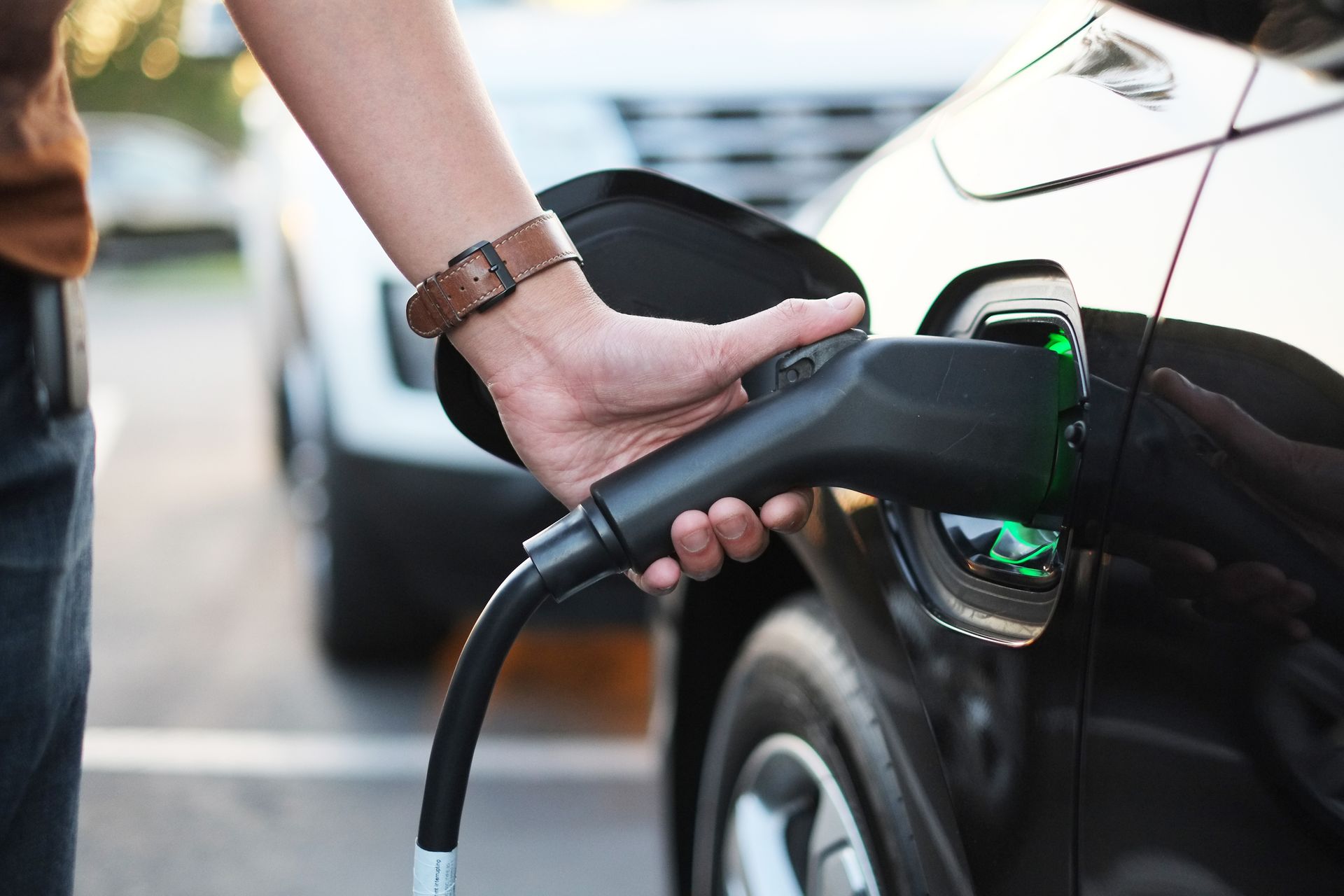 Une personne charge une voiture électrique avec un chargeur.