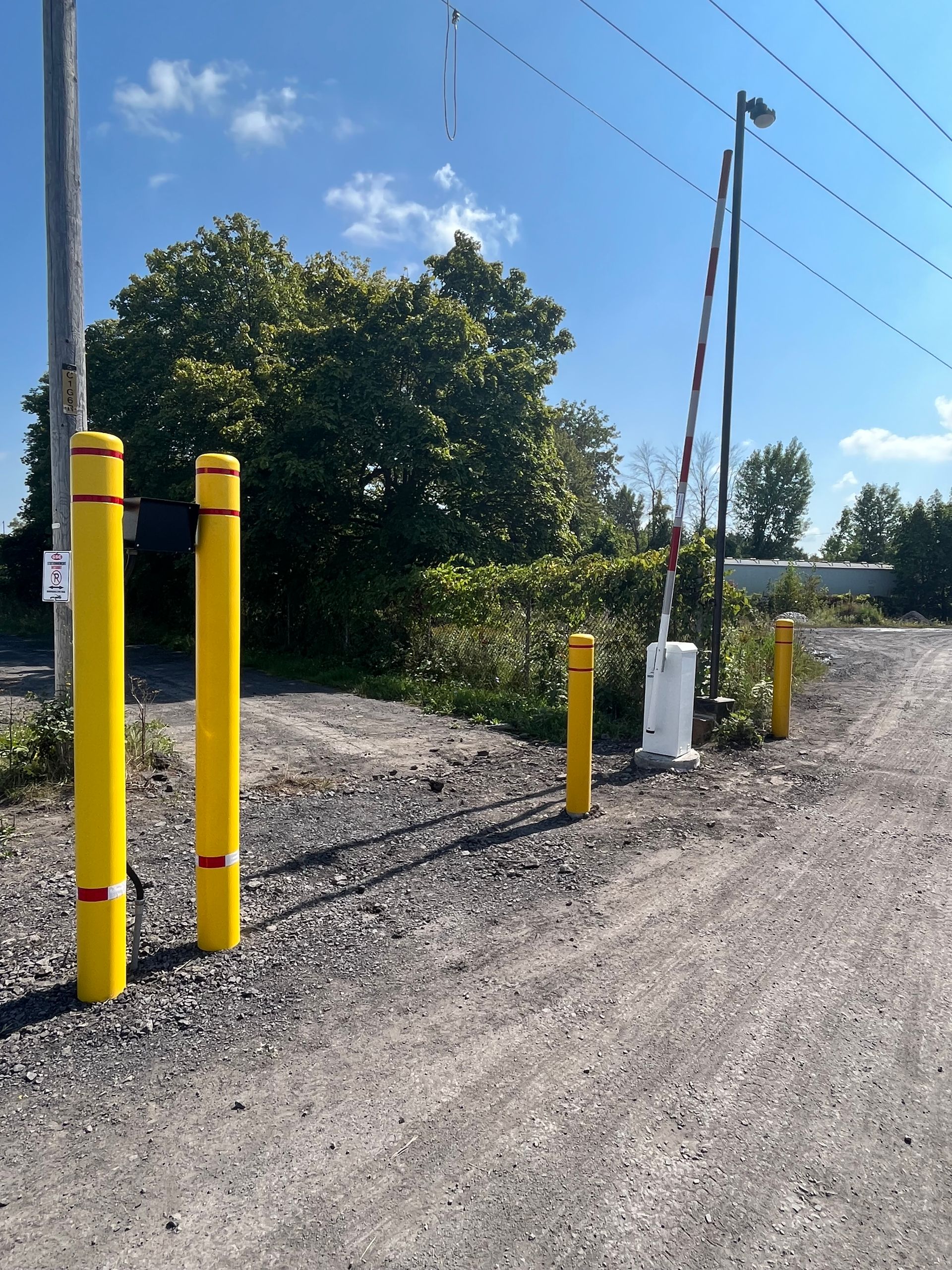 Un chemin de terre avec des poteaux jaunes sur le côté