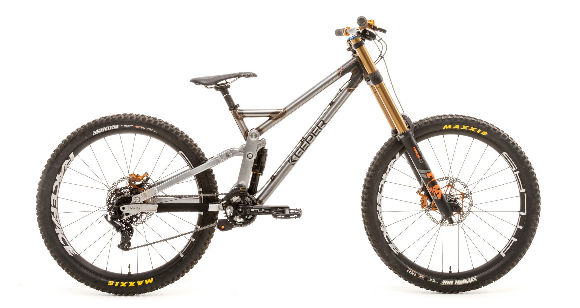 Gray and orange mountain bike with large tires and suspension fork.